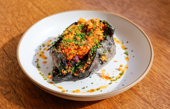 Camote at Broken Spanish Comedor, a coal roasted japanese sweet potato with salsa macha butter, pork rinds, and chives.
