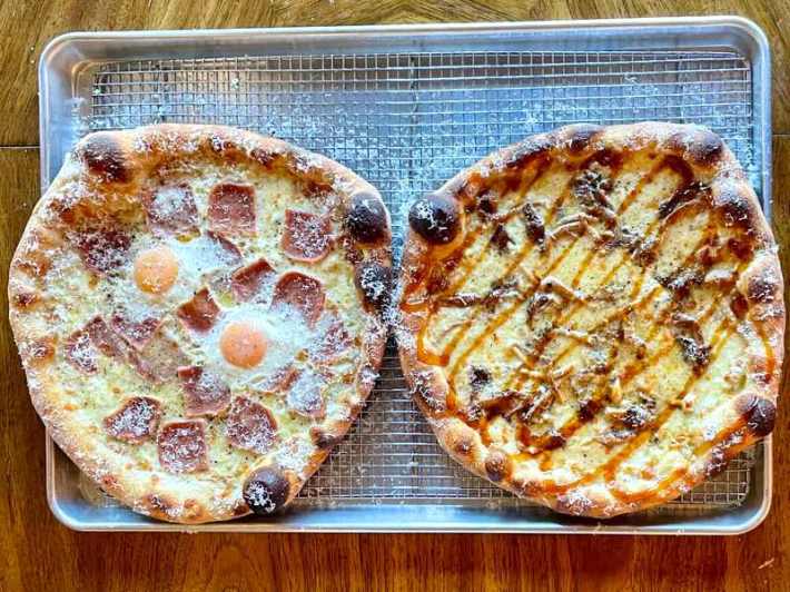 Spam carbonara pizza, left, and mushroom adobo pizza, at Wallflour Pizza, on a metal screen tray