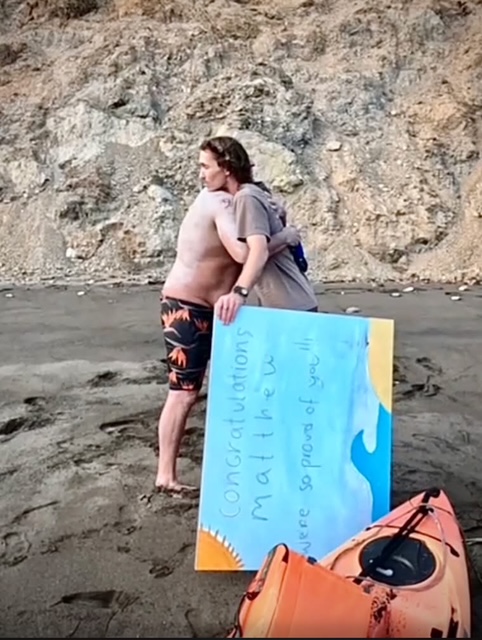 Matthew Biancaniello hugging a recipient of some of the money he raised for Indivisible Arts at Smuggler's Cove in Palos Verdes.