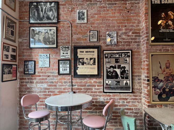 FUNHOUSE's red brick wall adorned with punk memorabilia.