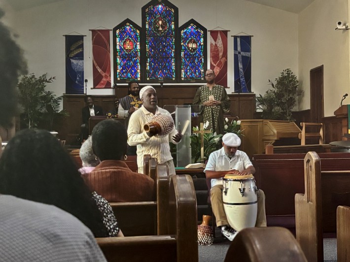 In a church, two men perform on percussion instruments.