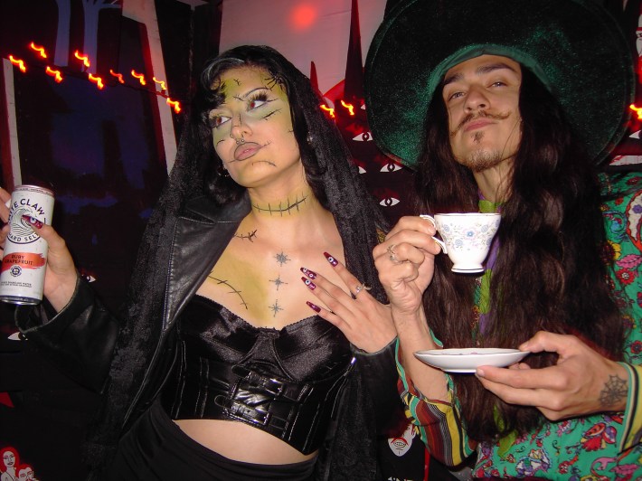 A woman dressed as Frankenstein is next to a mustached man dressed as the Mad Hatter
