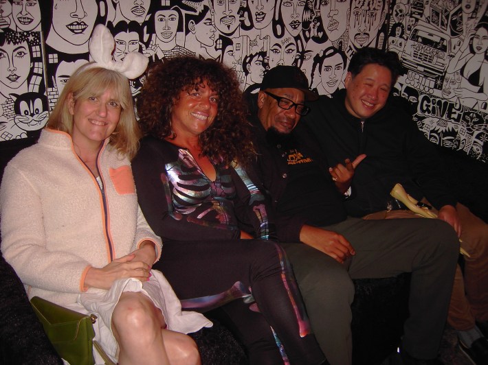 Two women and two men sit comfortably together on a couch