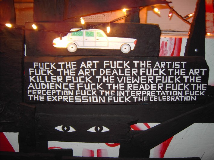 A piece of artwork at Albert Reyes' home shows a car and beneath it text condemning art, artists, art dealers, and more.