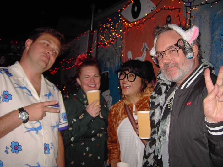 A man, two women, and another man happily pose for the camera