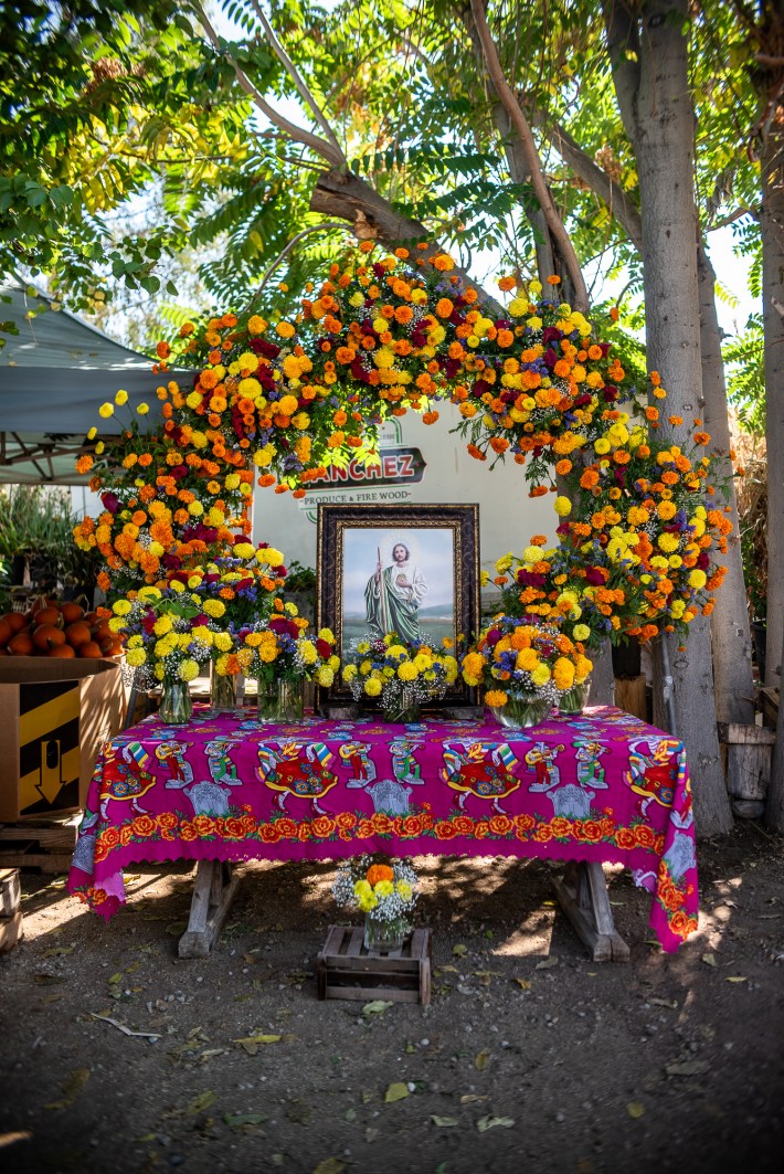 an outdoor altar on a table is decorated with flowers