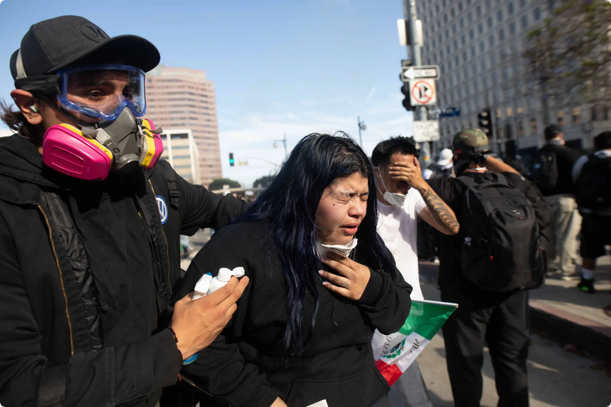 A woman chokes on tear gas fumes in Downtown L.A., June 14, 2025