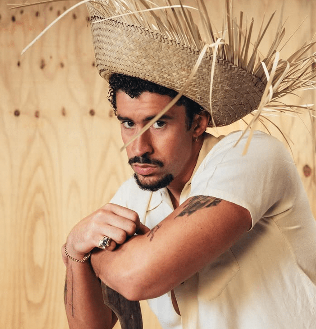 Bad Bunny, a man wearing a straw hat, looks into the camera.