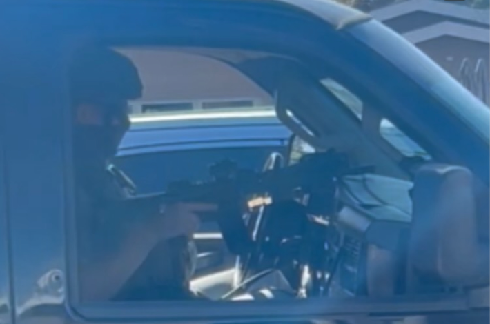 an officer in a car brandishing a gun