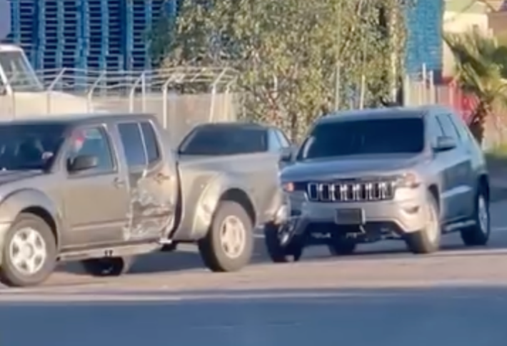 A truck's passenger side is damaged, and a silver Jeep is following behind.