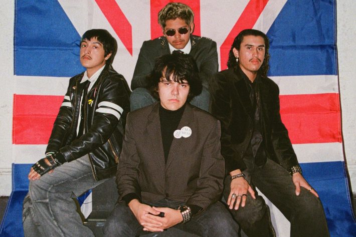 four men pose in front of a union jack