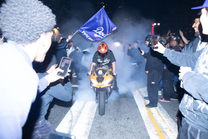 A motorcyclist drives through a crowd