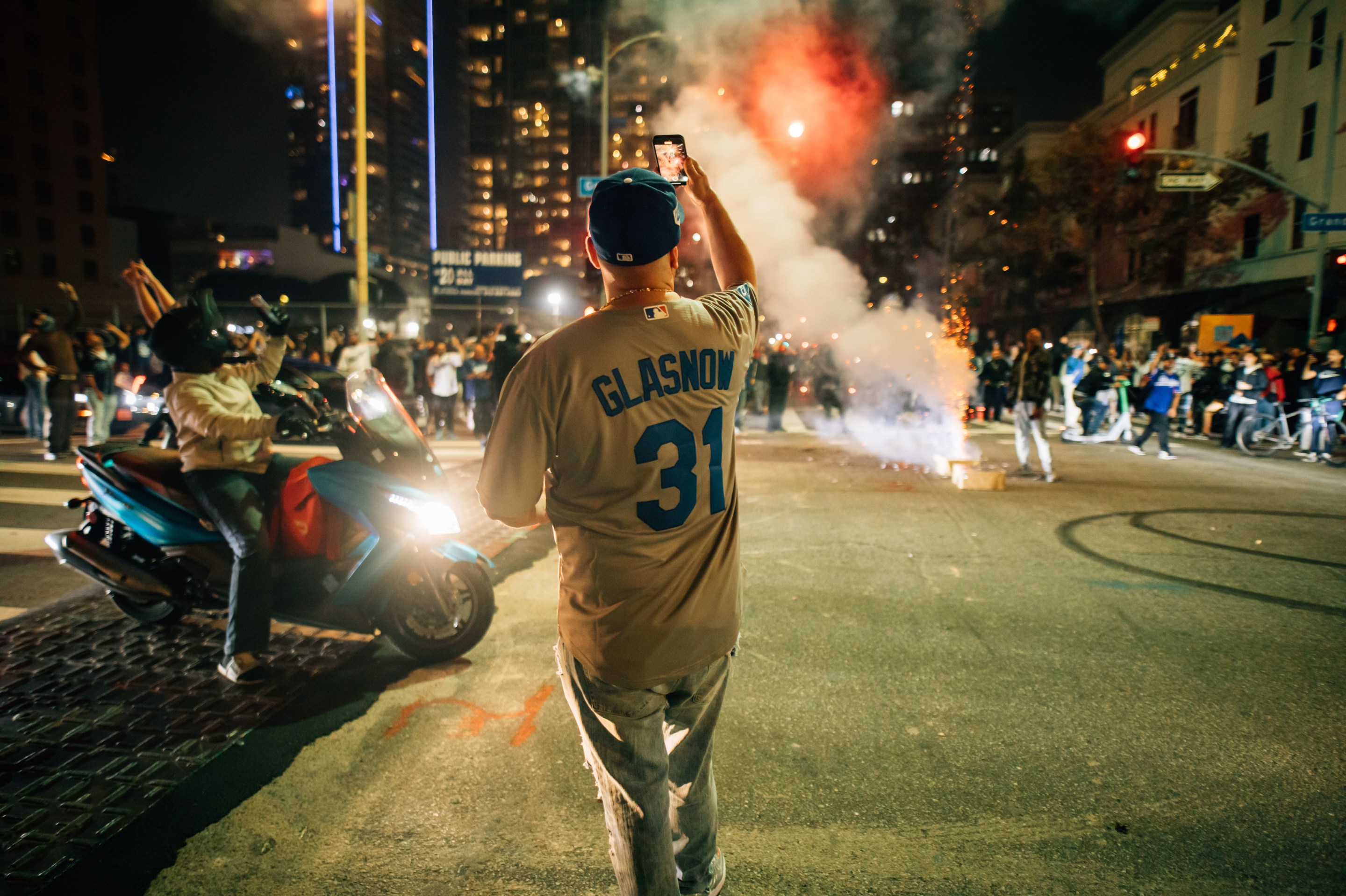 A man is facing backwards wearing a jersey in front of smoke and fire.