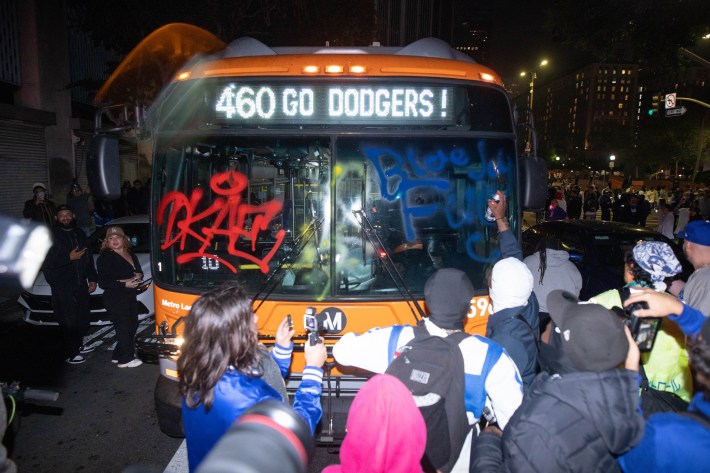 People spray paint a city bus