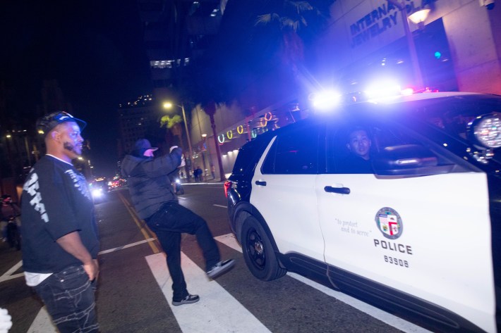 Two men look at a police SUV