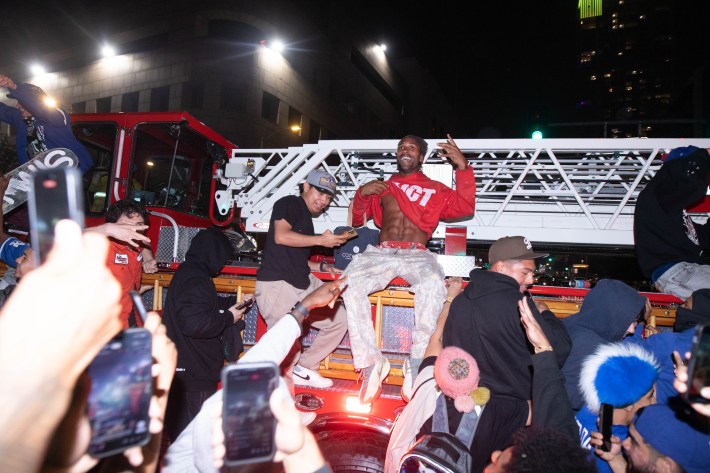 Two men pose on a firetruck