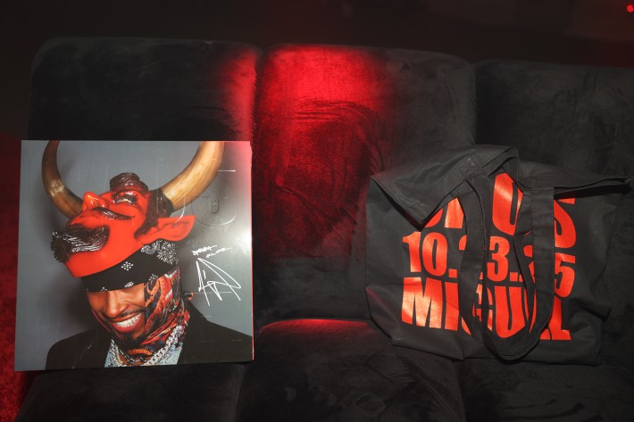 a vinyl album sits on a couch next to a tote bag