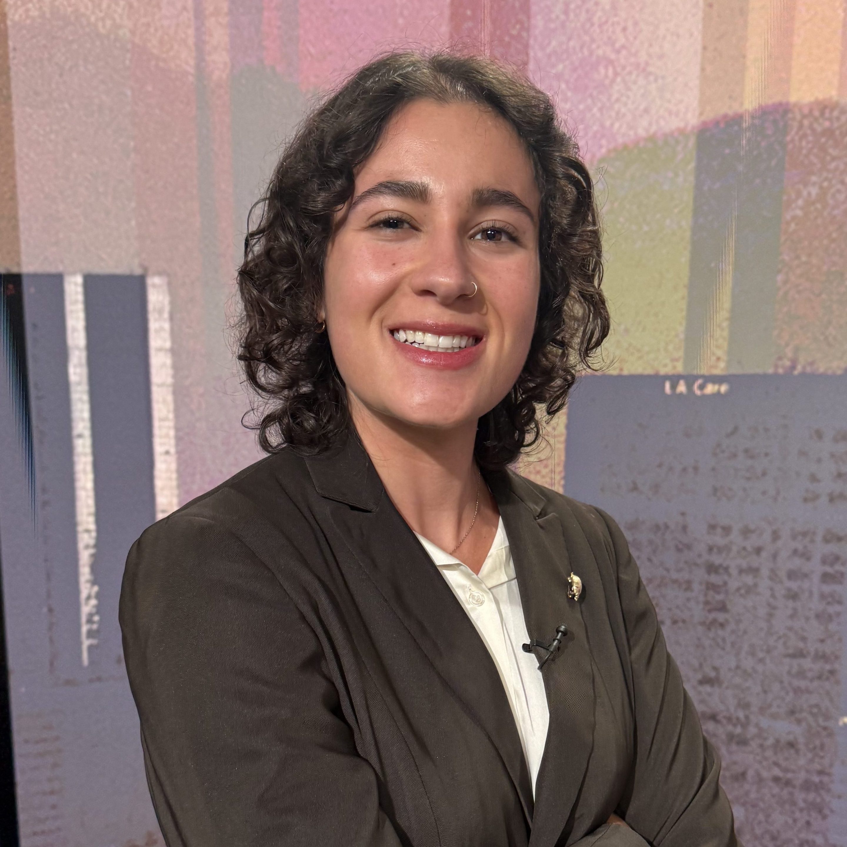 a woman smiles while wearing a suit