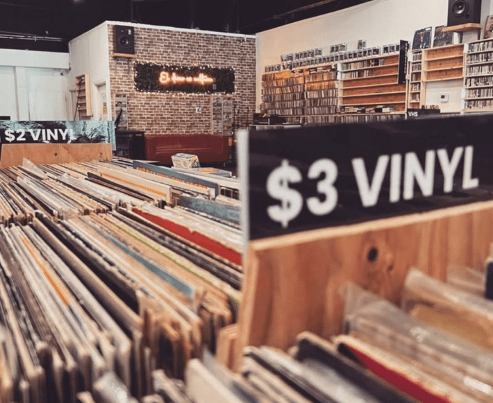 a shot from inside a record store. loads of vinyls and CDs are packed on the shelves