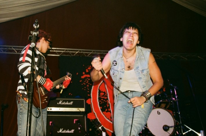 young men in a band play onstage