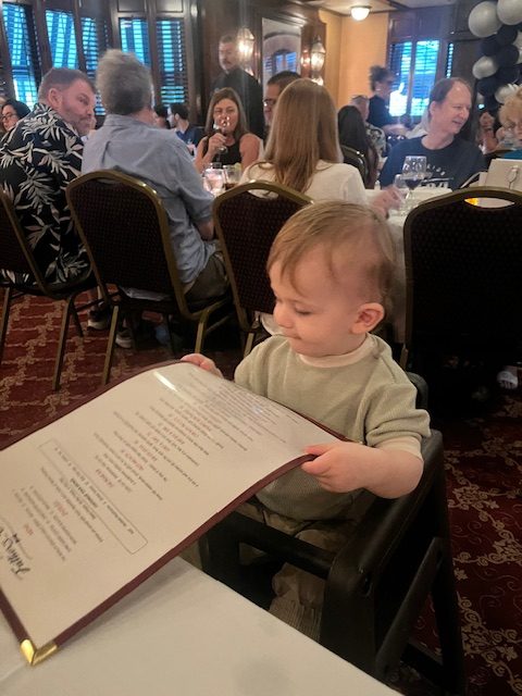 A toddler plays with a menu
