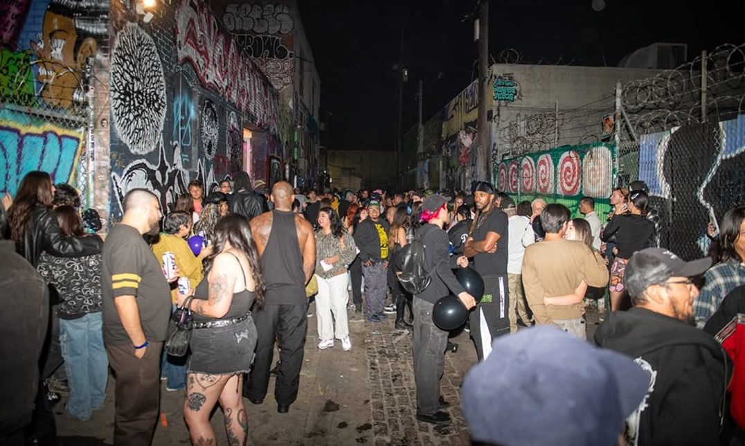 a crowd of people gather outside at nighttime