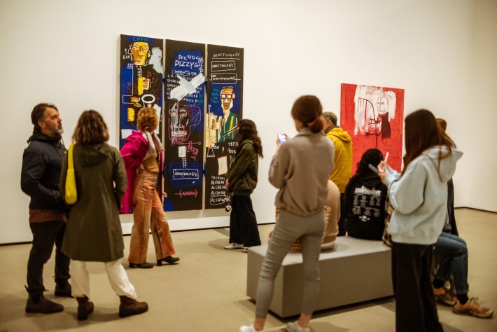 people in front of paintings at a gallery