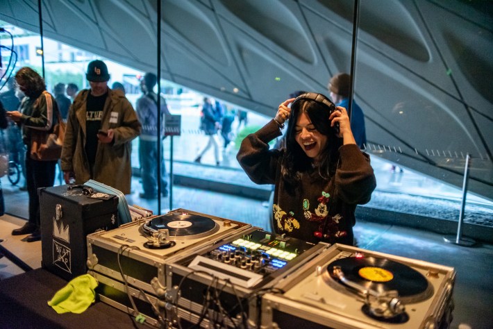 a woman DJs at a DJ deck