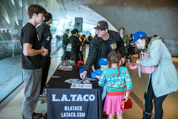 a family is at an L.A. TACO merch table