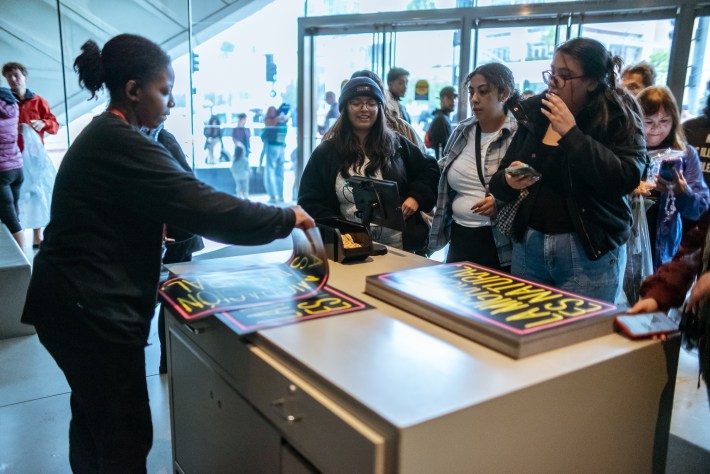 a museum worker folds a poster