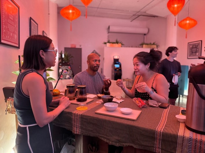a woman hosting a tea bar speaks with her customers