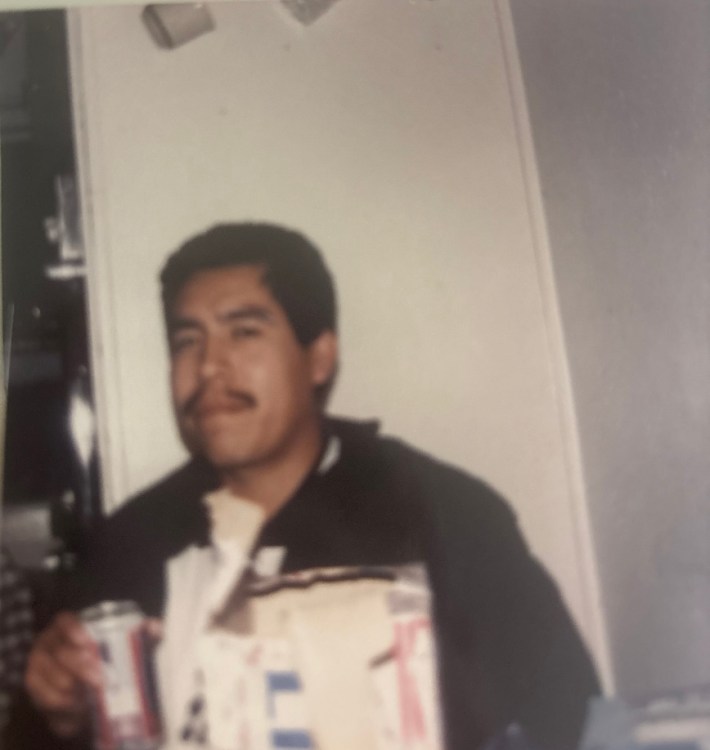 a young man holds a can and looks into the camera