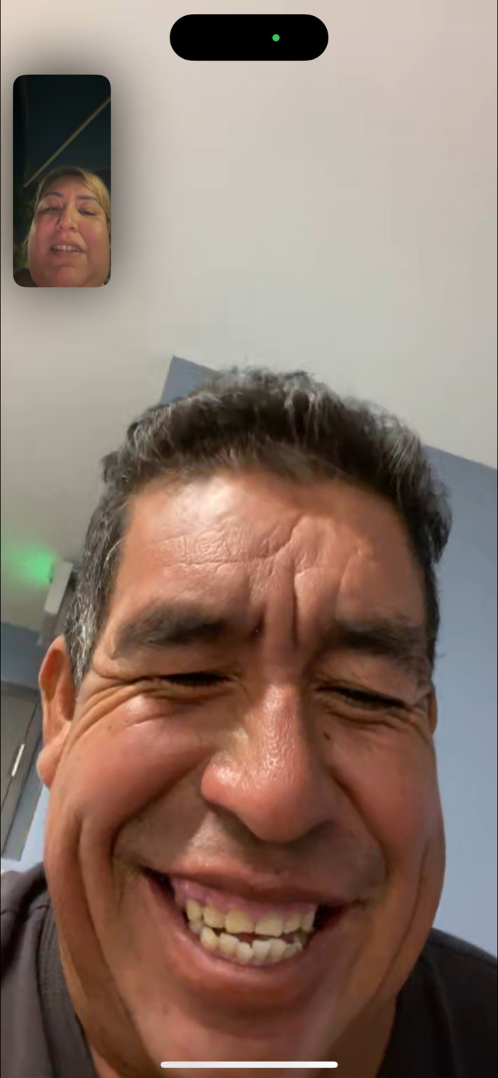 a man smiles while on FaceTime with a woman