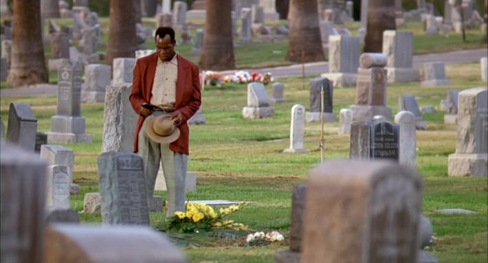 a man is at a grave yard paying his respects
