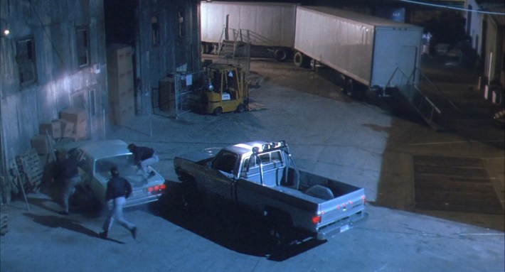 a truck pulls up to a crowd of men in a lot