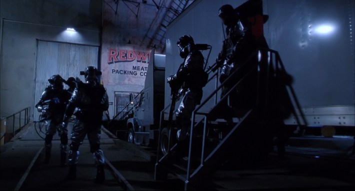 men gather in a walk-in fridge