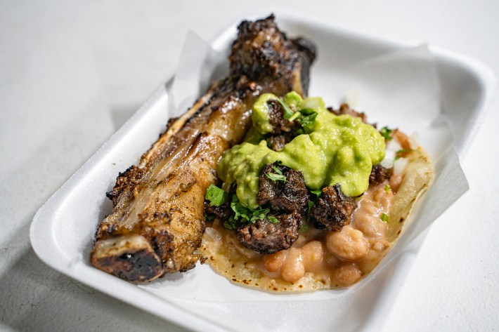 a large rib bone served with a taco