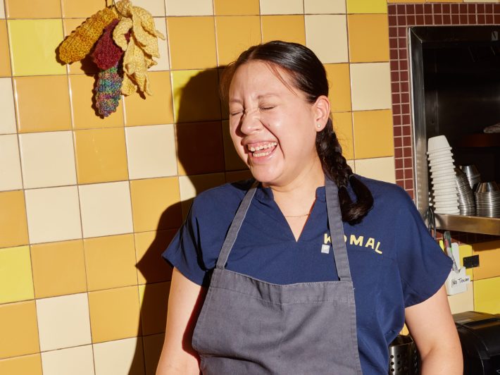 a woman laughs, her eyes closed