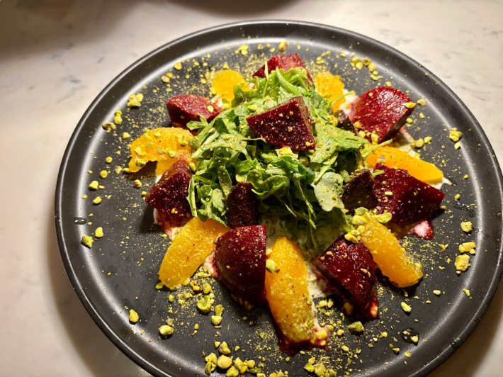 a plate of beets, citrus, and greens