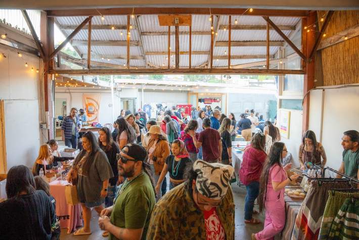 a crowd of people together at an indoor flea market