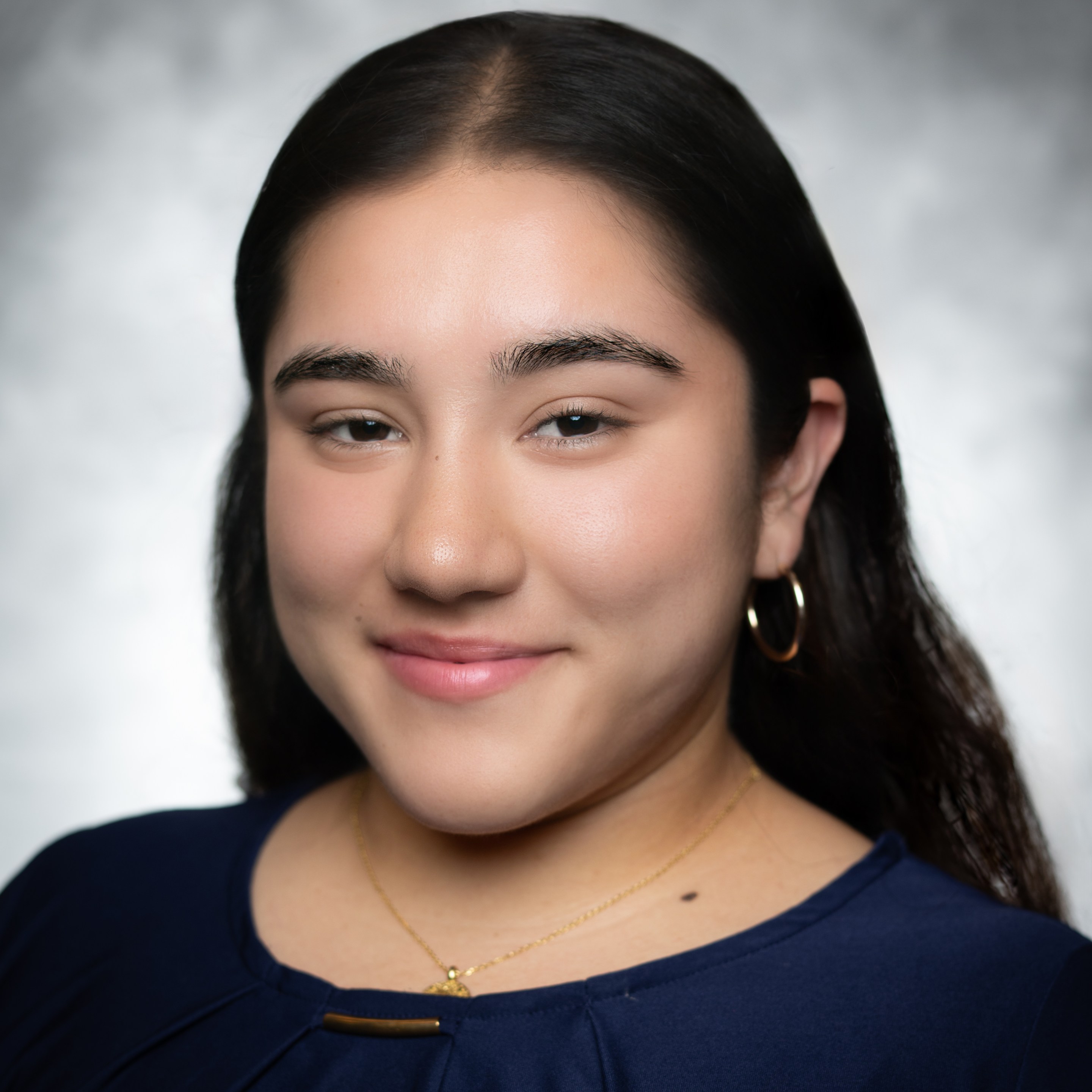 a young woman's headshot shows her smiling into the camera