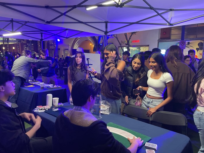 students perform magic for attendees at a block party