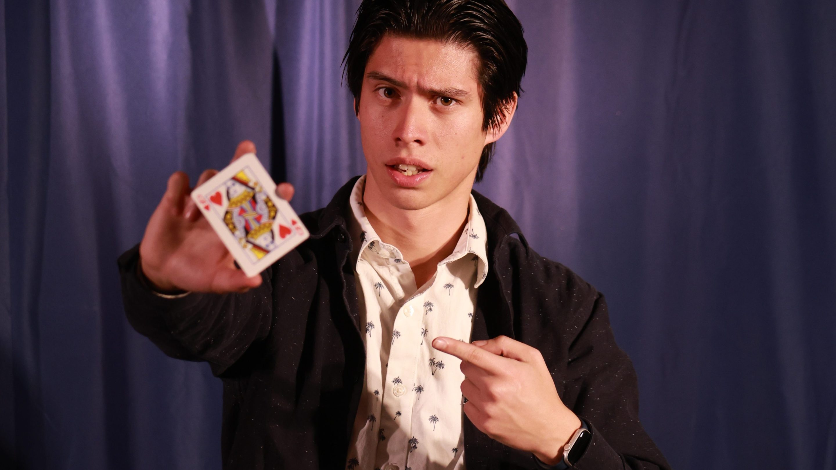 a young man points to a playing card