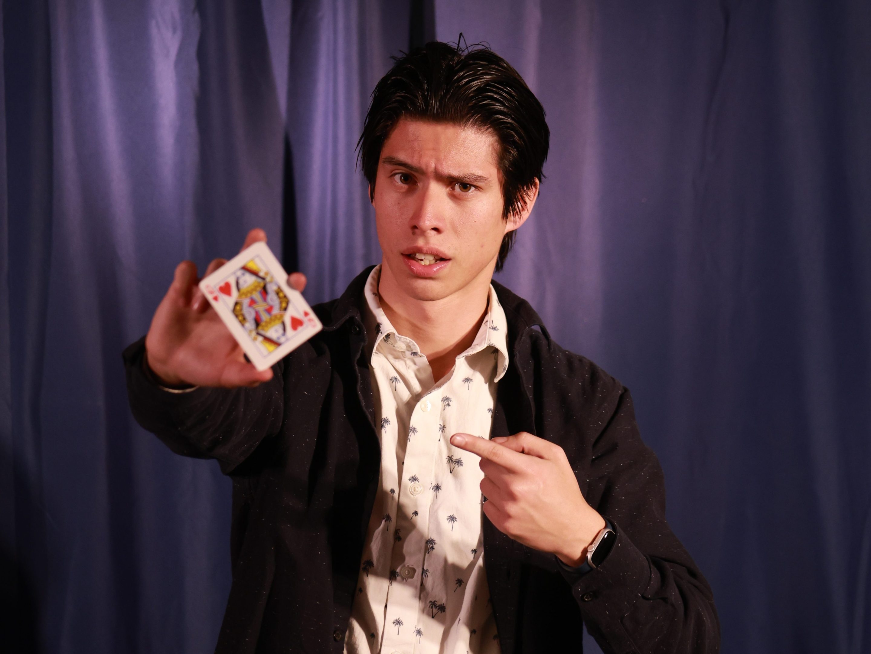 a young man points to a playing card