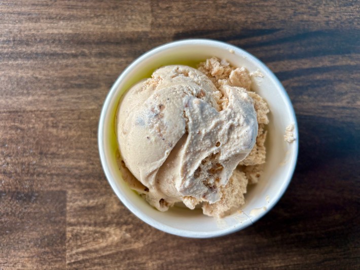 a scoop of ice cream in a bowl on a wooden table