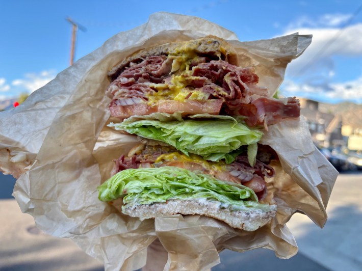 a pastrami burger with lettuce, tomato, and mustard