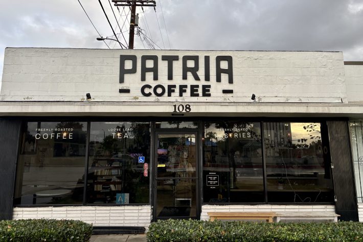 exterior of a coffee shop called Patria Coffee. It is a black and white simple exterior