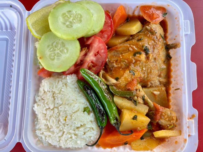 a plastic container of rice, vegetables, and chicken