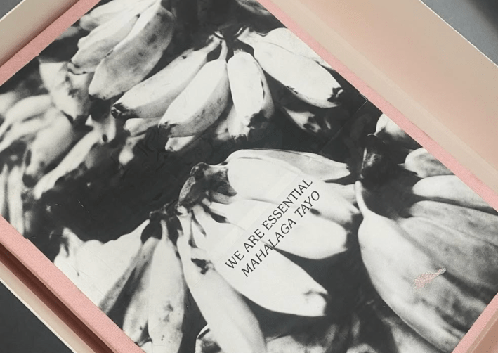 a closeup of a zine cover with the title "we are essential" on top of a black and white floral background