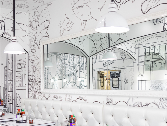 An illustrated dining room drawn in a black-and-white 2-D style with sharks and a bookshelf around a real mirror